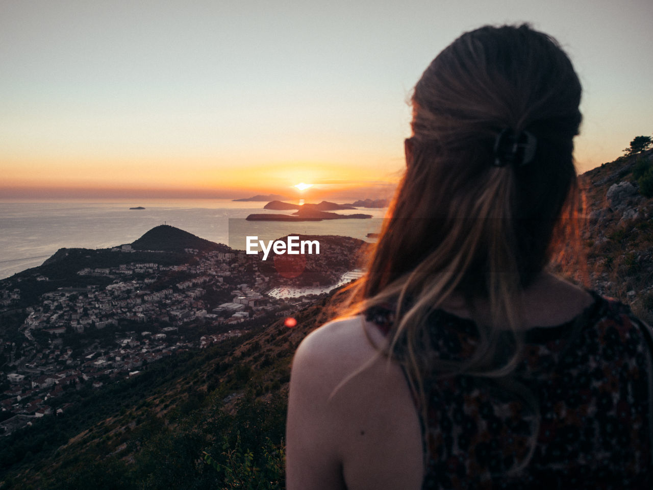 Woman looking at view against sky during sunset