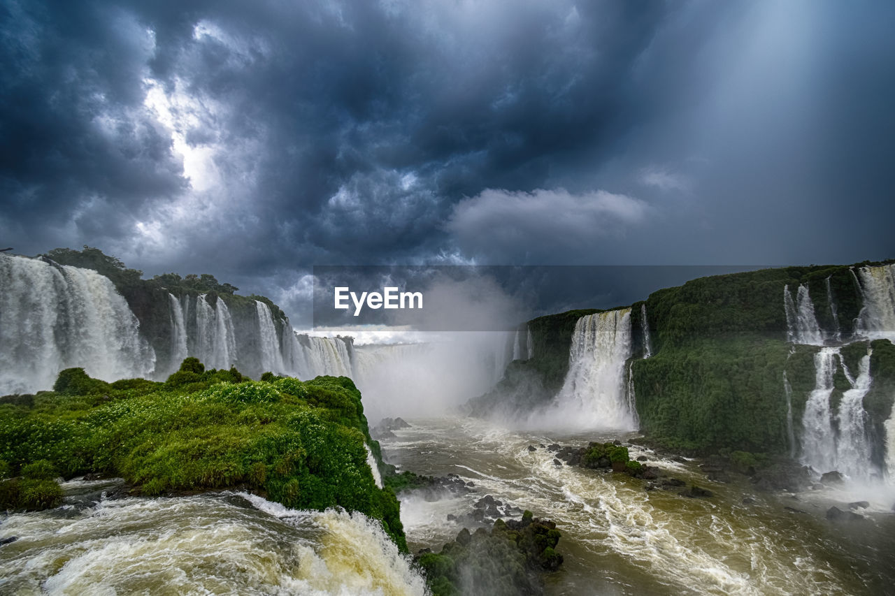 Panoramic view of waterfall against cloudy sky - cataratas do iguaçu