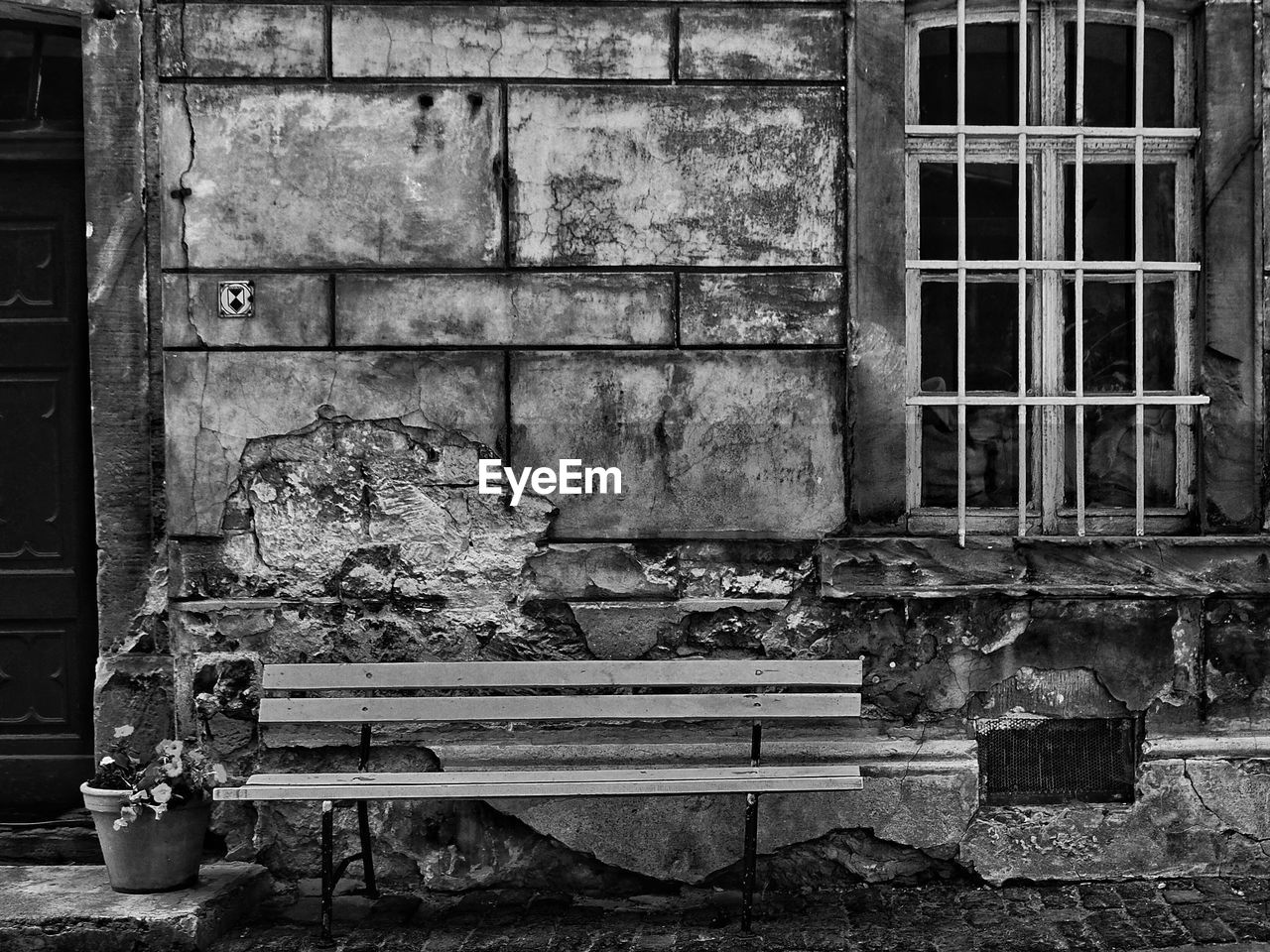 Empty bench against old abandoned building