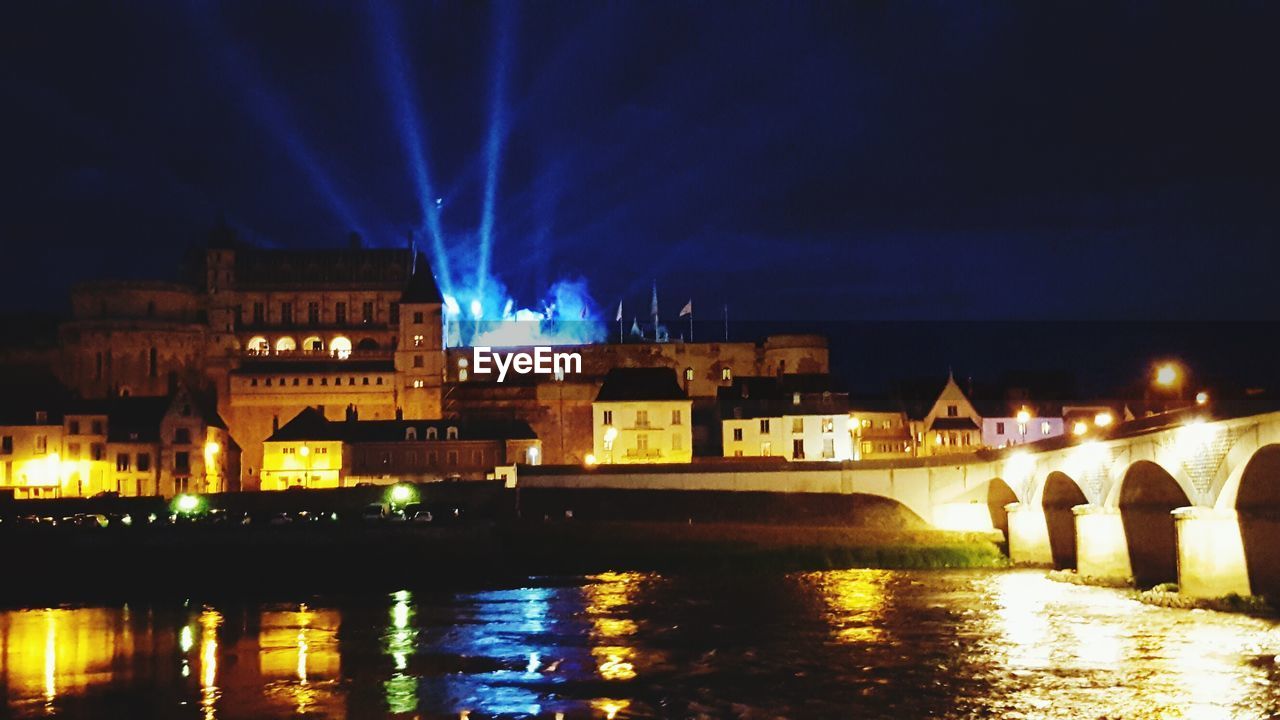 REFLECTION OF ILLUMINATED BUILDINGS IN WATER AT NIGHT