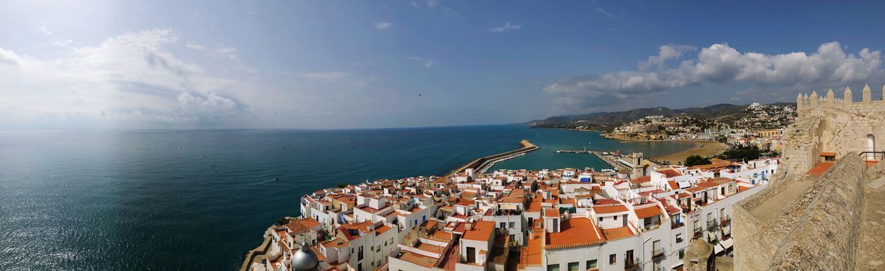 High angle view of townscape by sea against sky