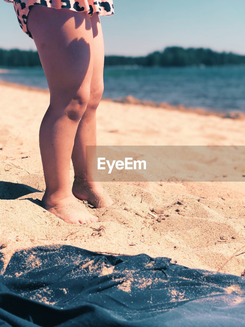 LOW SECTION OF PERSON STANDING ON SHORE