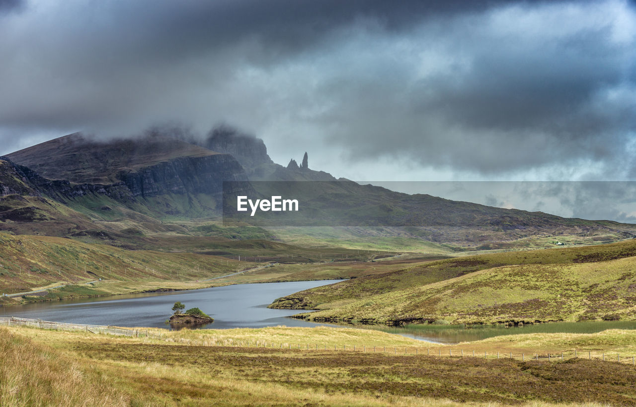 Scenic view of lake by mountains against sky