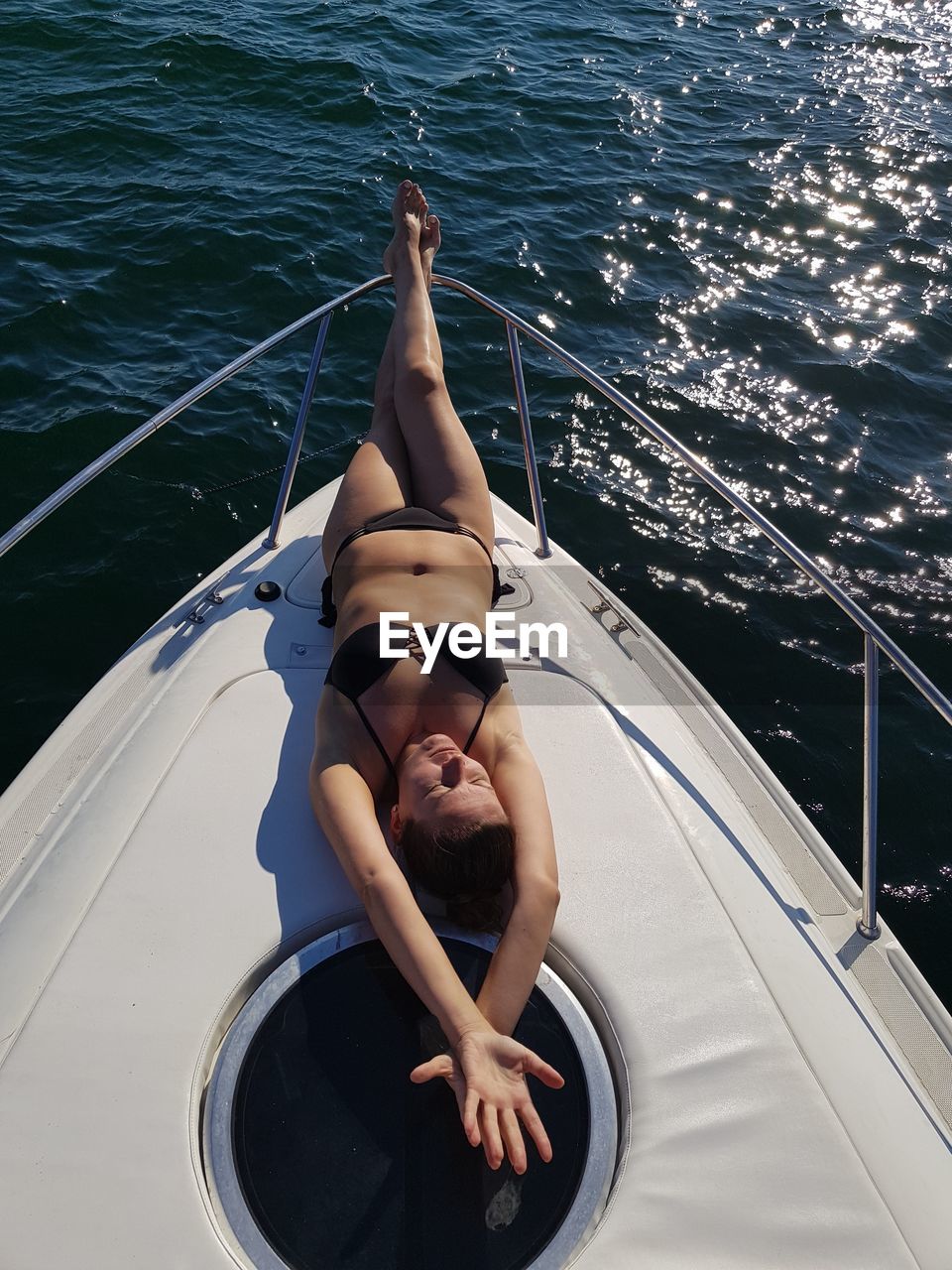 Woman lying on boat in sea