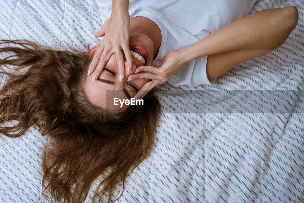 Young woman wakes up after a good night's sleep in