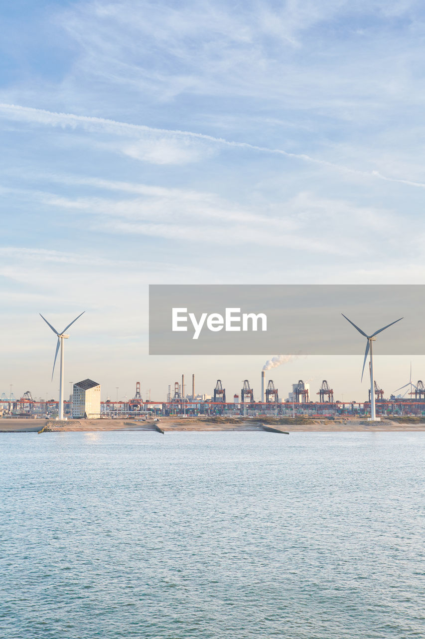 A commercial shipping dock with wind turbines in rotterdam, netherlands