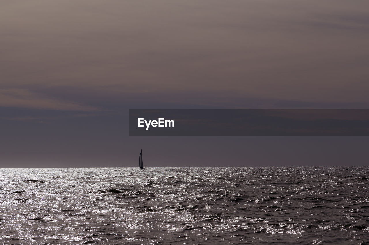 SAILBOATS IN SEA AGAINST SKY DURING SUNSET