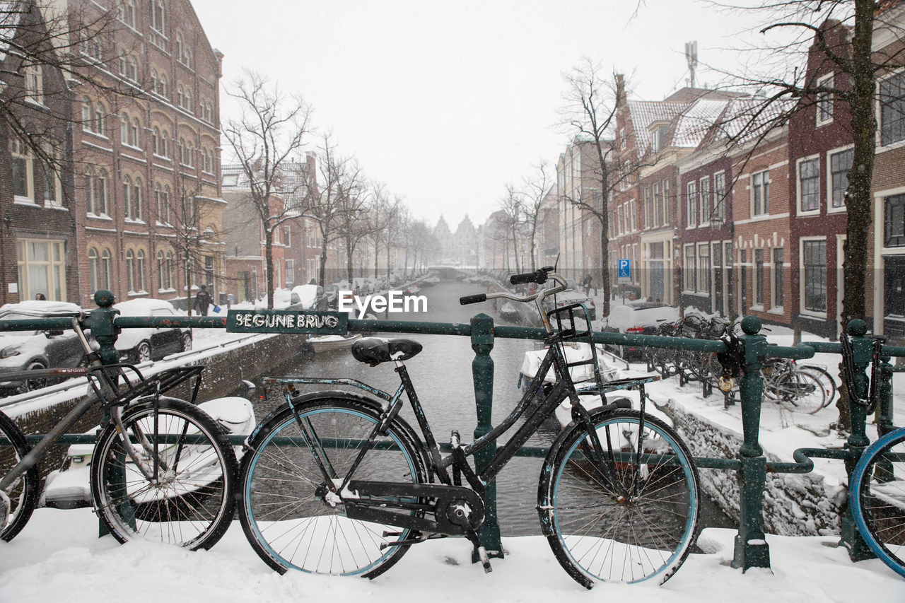 BICYCLE PARKED ON SNOW COVERED CITY
