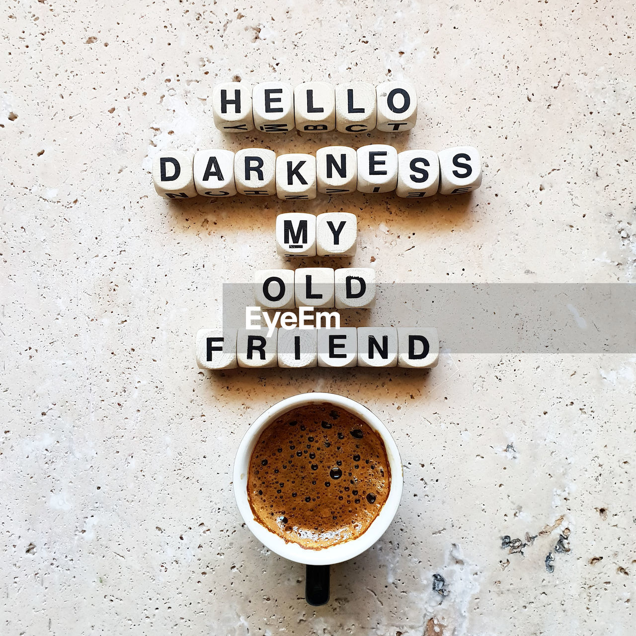 Directly above shot of coffee cup with text on stone table 