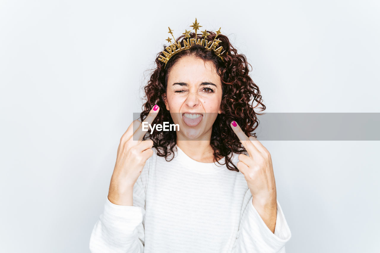 Portrait of woman gesturing while standing against white backgrounds