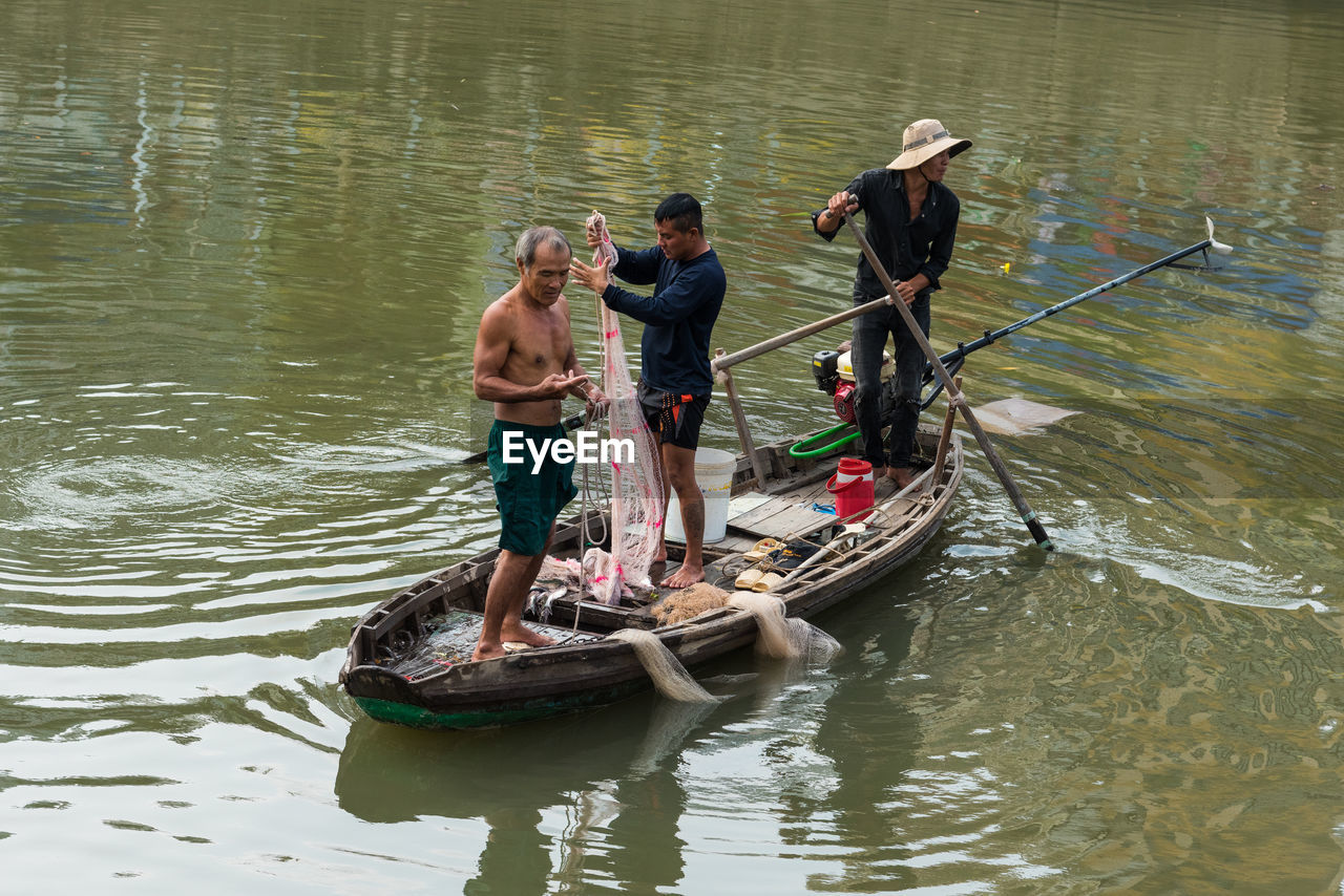 HIGH ANGLE VIEW OF PEOPLE IN BOAT ON LAKE