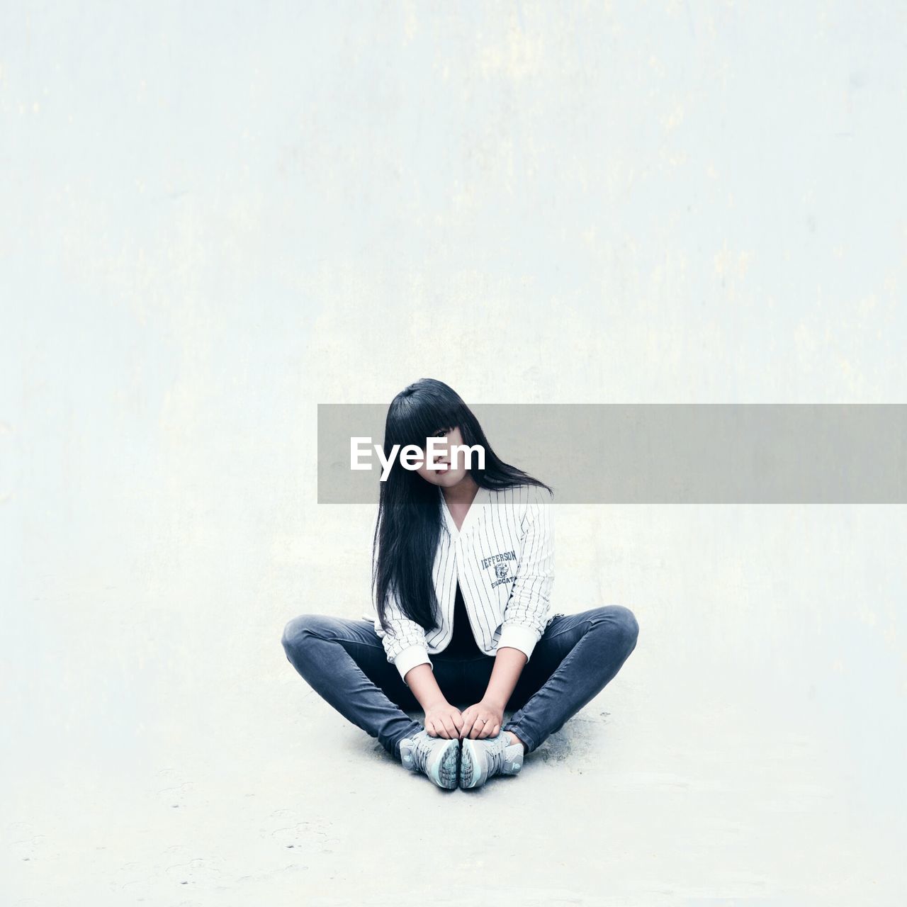 Young woman sitting on white background