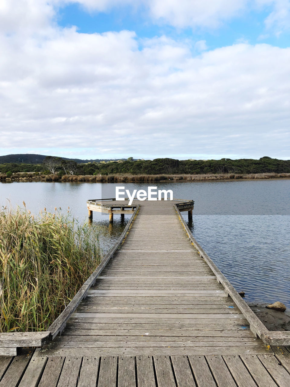 WOODEN PIER ON LAKE AGAINST SKY