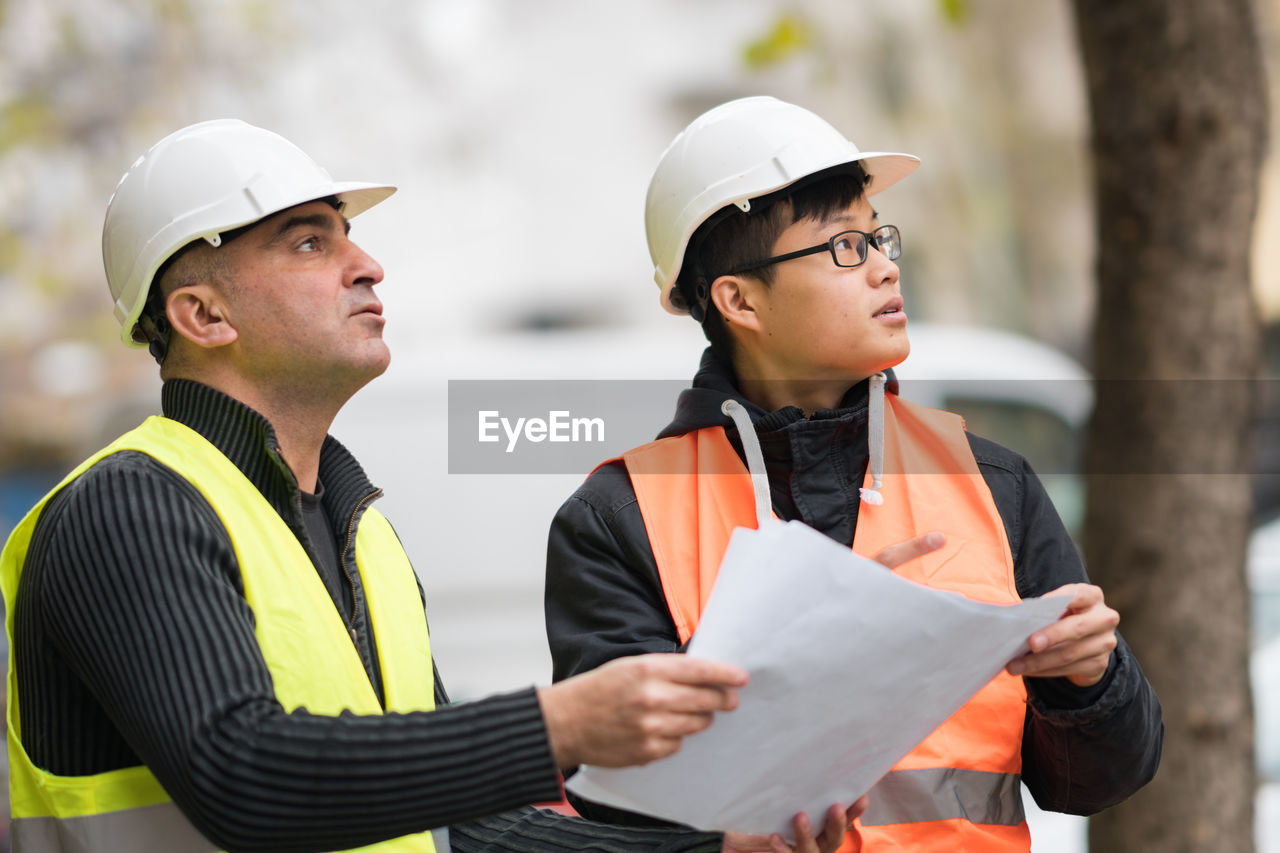 Engineers discussing while standing at construction site