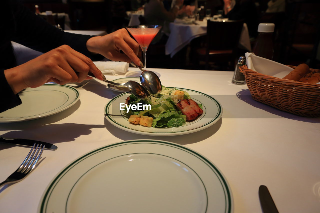 Cropped image of women having food at table in restaurant