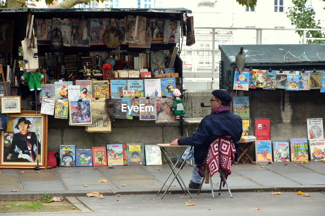 FULL LENGTH OF MAN SITTING ON MULTI COLORED SQUARE