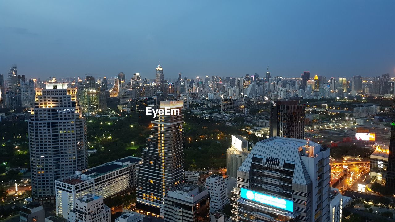 HIGH ANGLE VIEW OF ILLUMINATED BUILDINGS AGAINST SKY