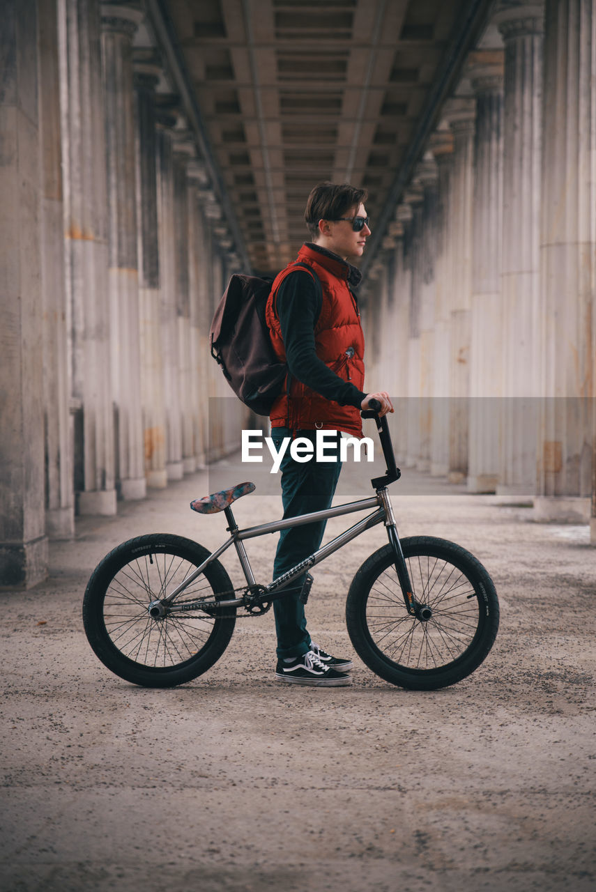 Man standing with bicycle in corridor