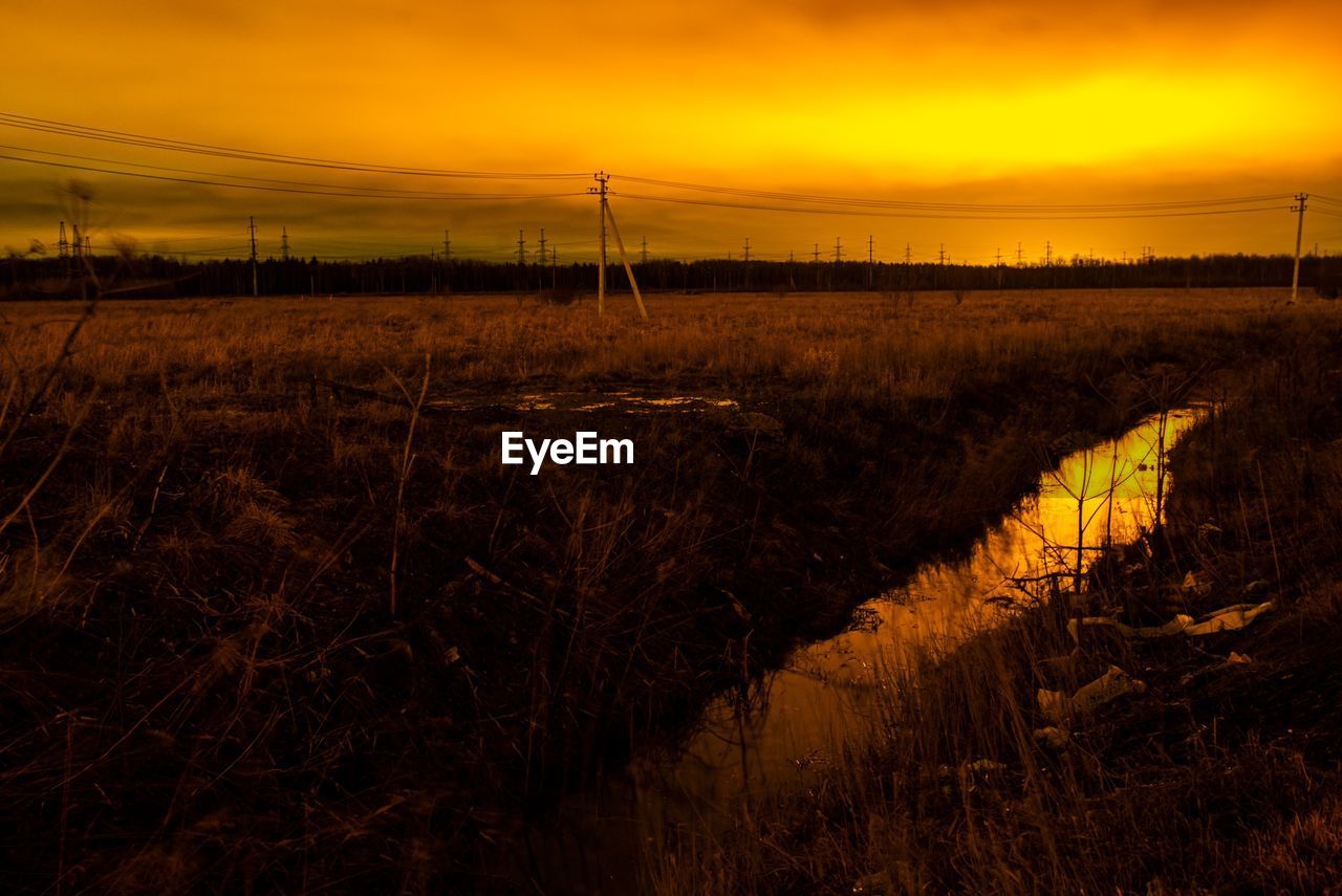 SCENIC VIEW OF FIELD AGAINST SKY AT SUNSET