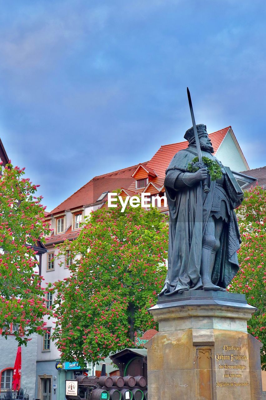 LOW ANGLE VIEW OF STATUE AGAINST BUILDING AND SKY