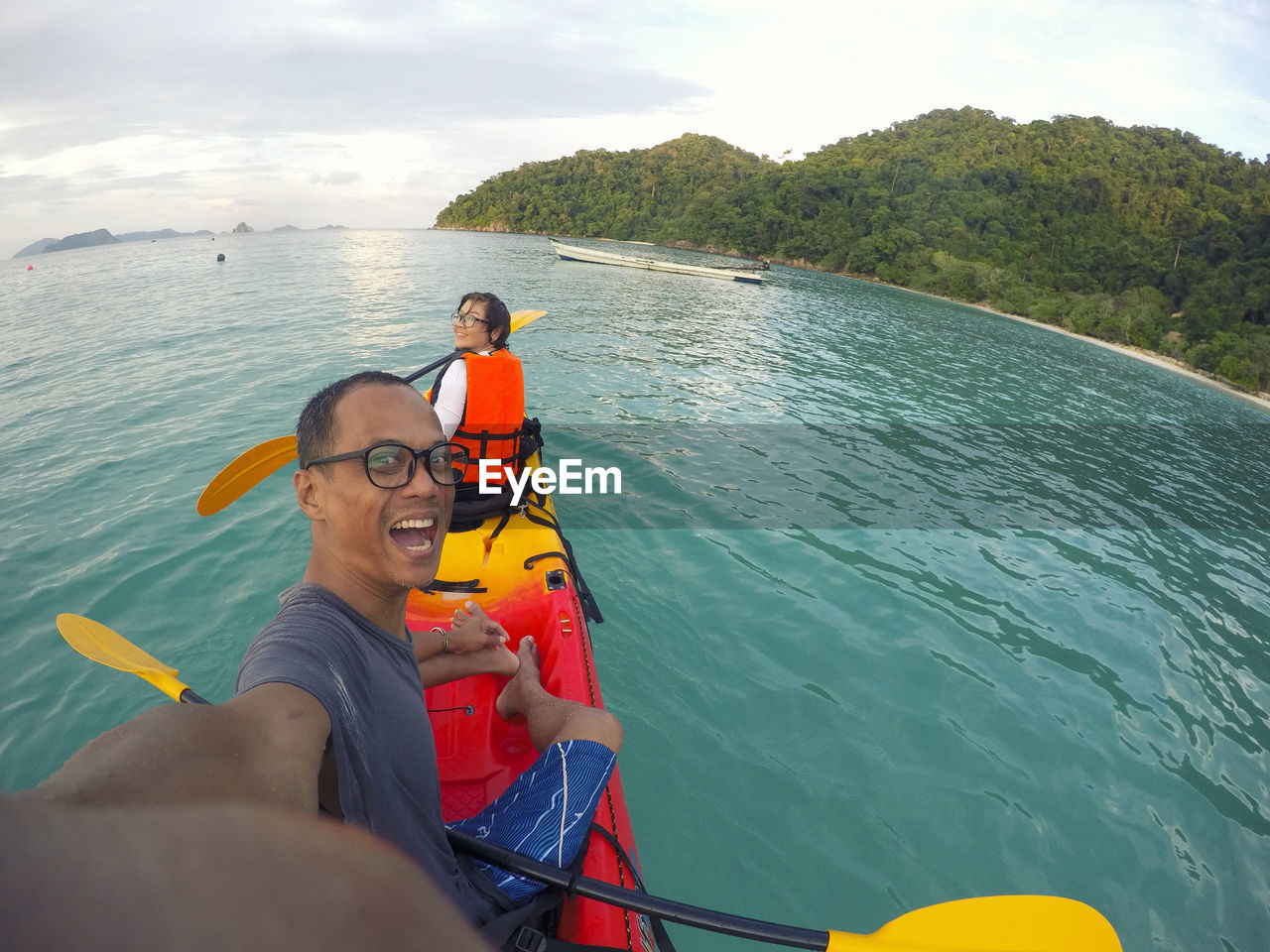 Portrait of cheerful couple kayaking in sea