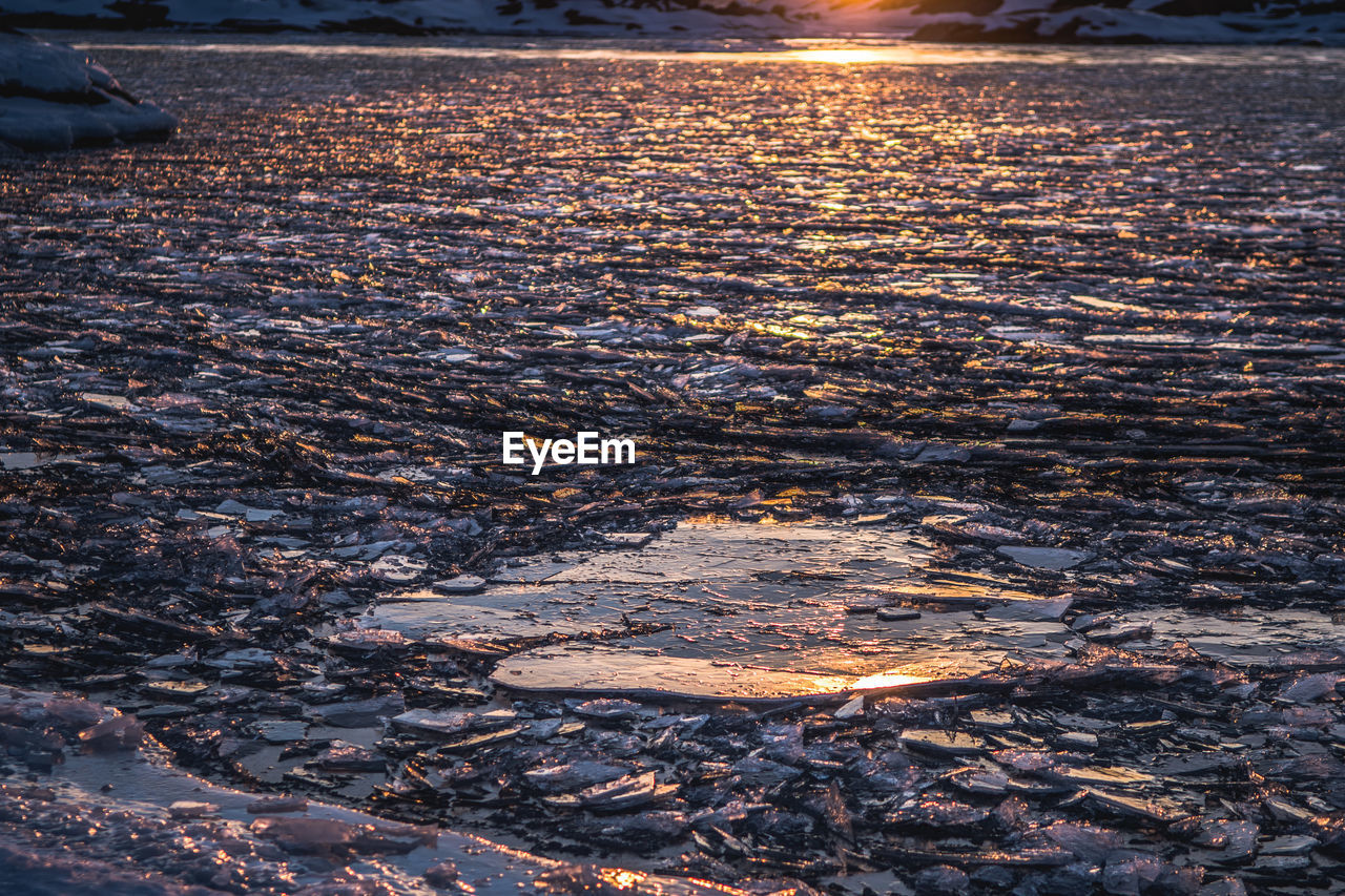 Scenic view of frozen lake against sky during sunset