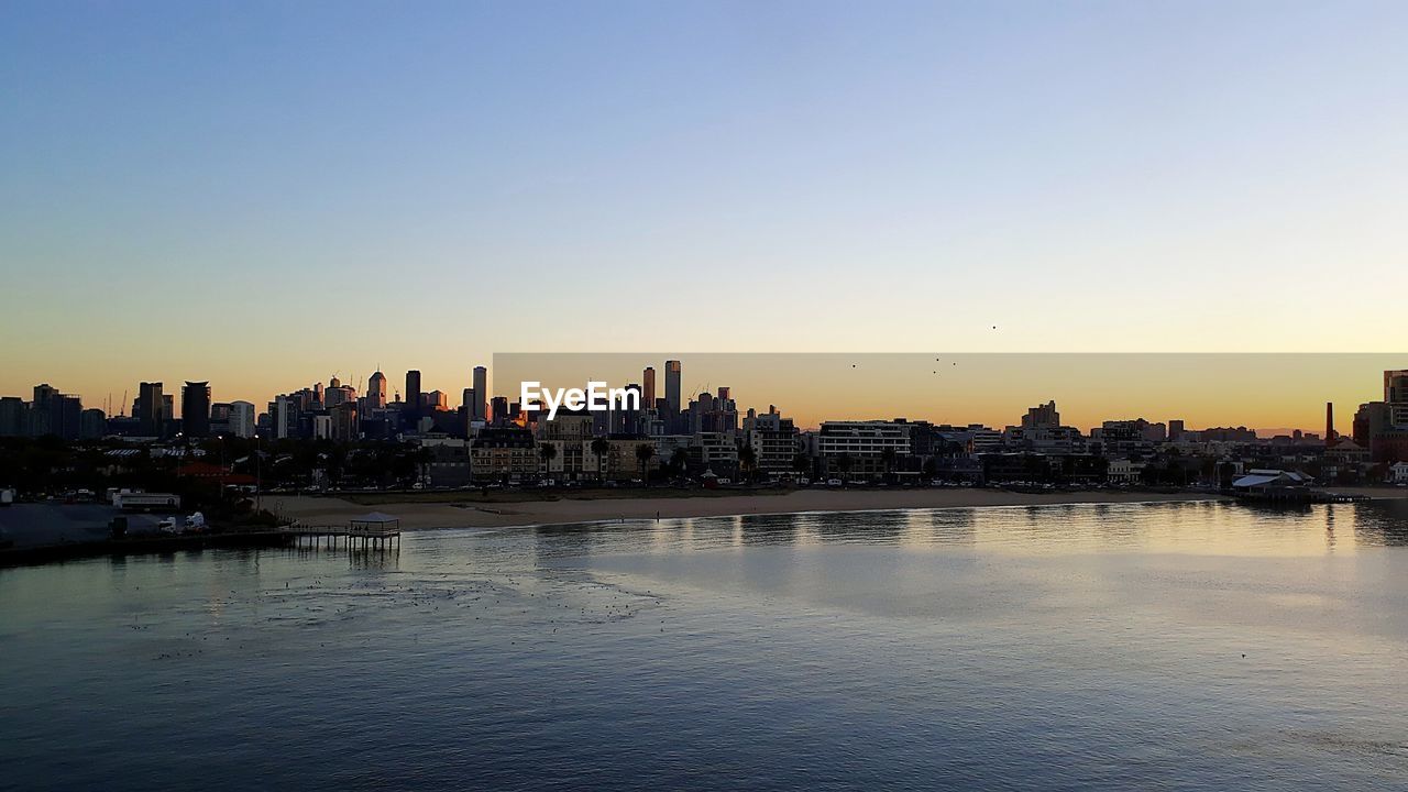 PANORAMIC SHOT OF BUILDINGS AGAINST SKY DURING SUNSET