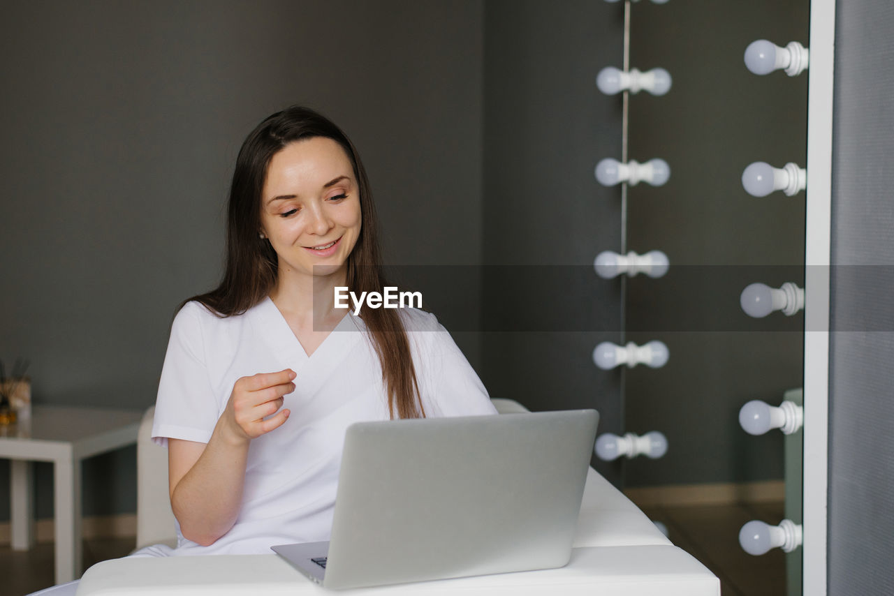 Cosmetologist conducts an online consultation on a laptop