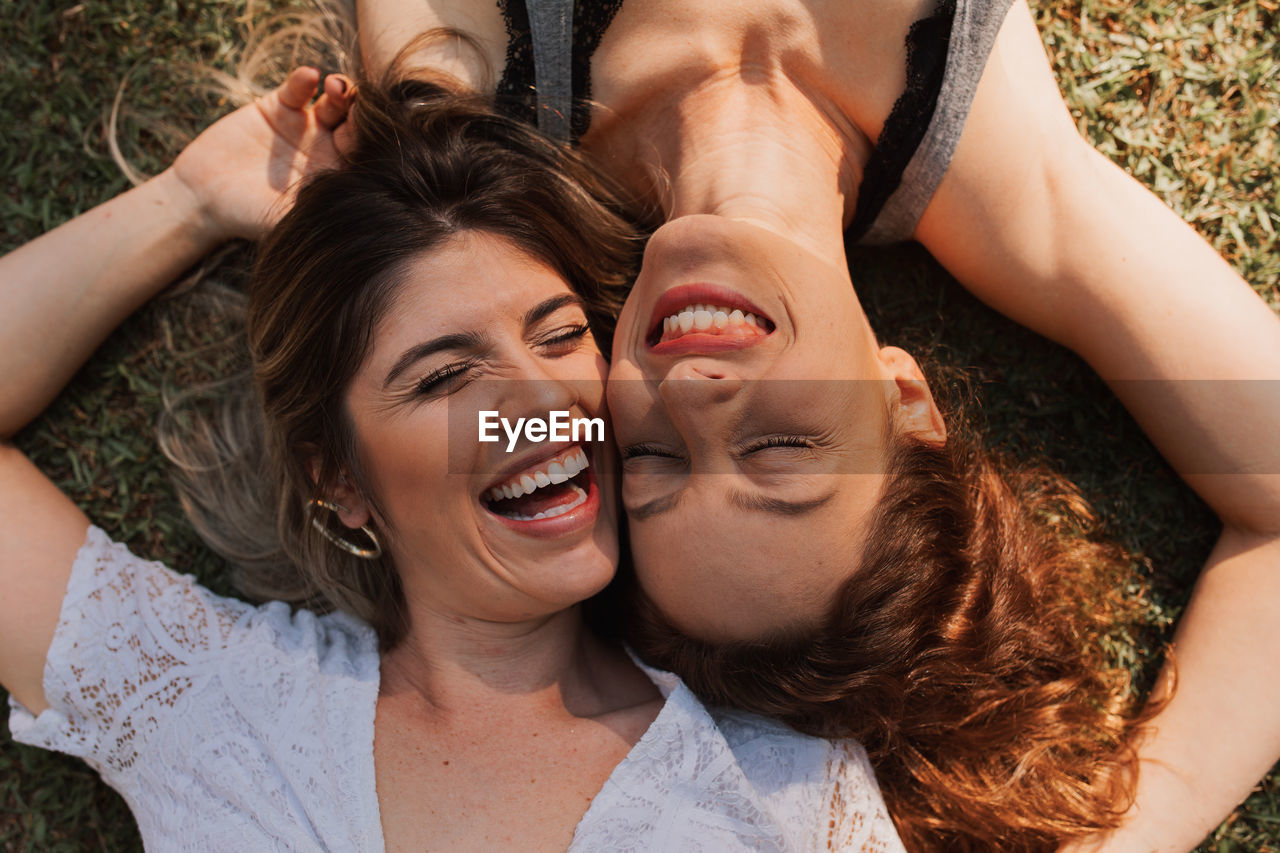 Portrait of smiling young people lying in the field