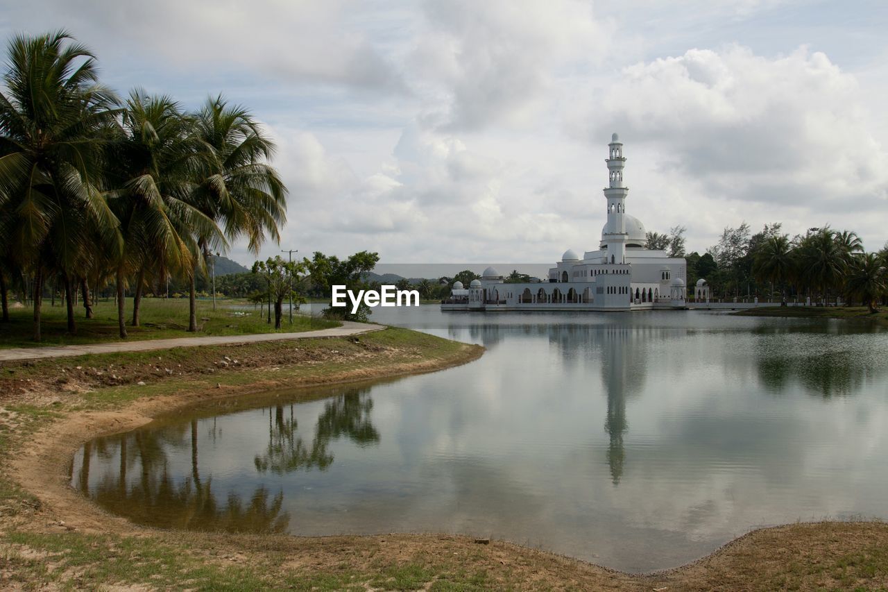 Tengku tengah zaharah mosque floating on lake at terengganu against cloudy sky