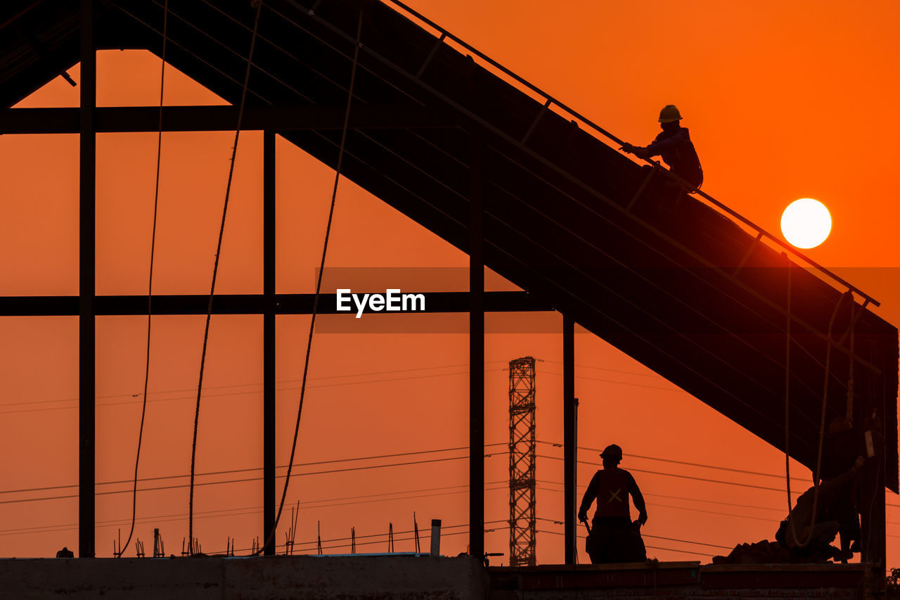 silhouette, sunset, evening, architecture, orange color, sky, dusk, transportation, built structure, men, nature, adult, night, industry, bridge, business, outdoors, horizon, light, line, working, occupation, standing