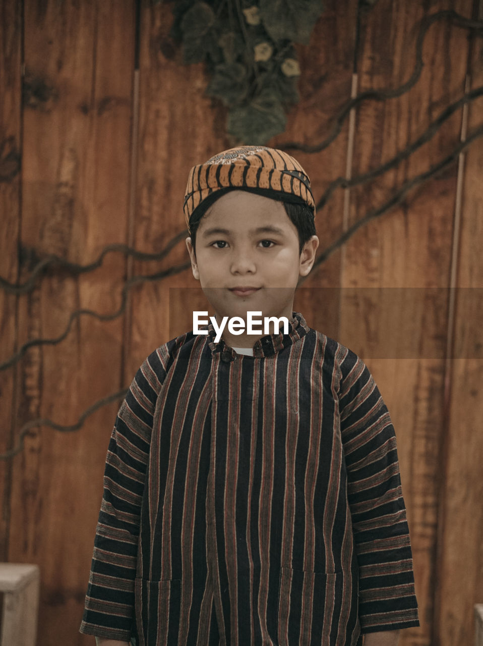 Portrait of boy standing against stone wall