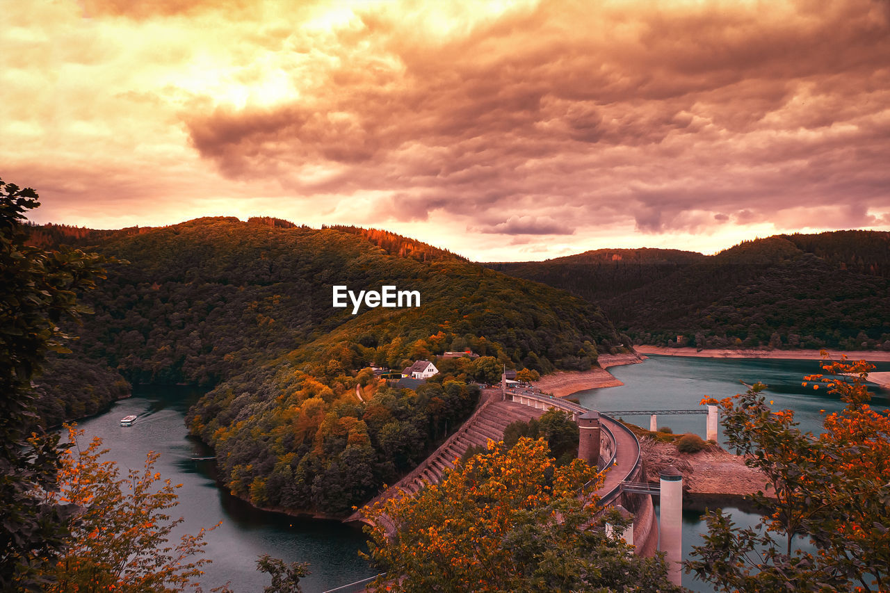 High angle view of river by trees against sky during sunset