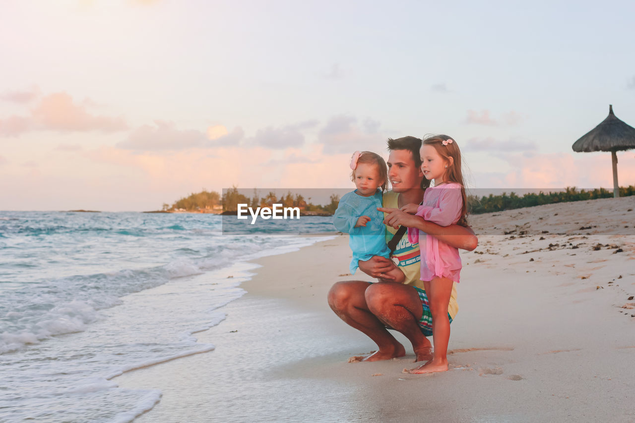 Full length of father with daughters at beach