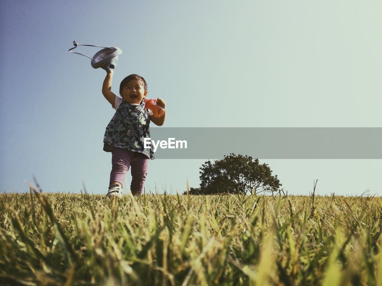 WOMAN STANDING ON GRASSY FIELD