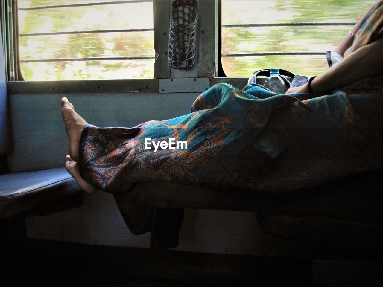 Barefoot woman traveling by train