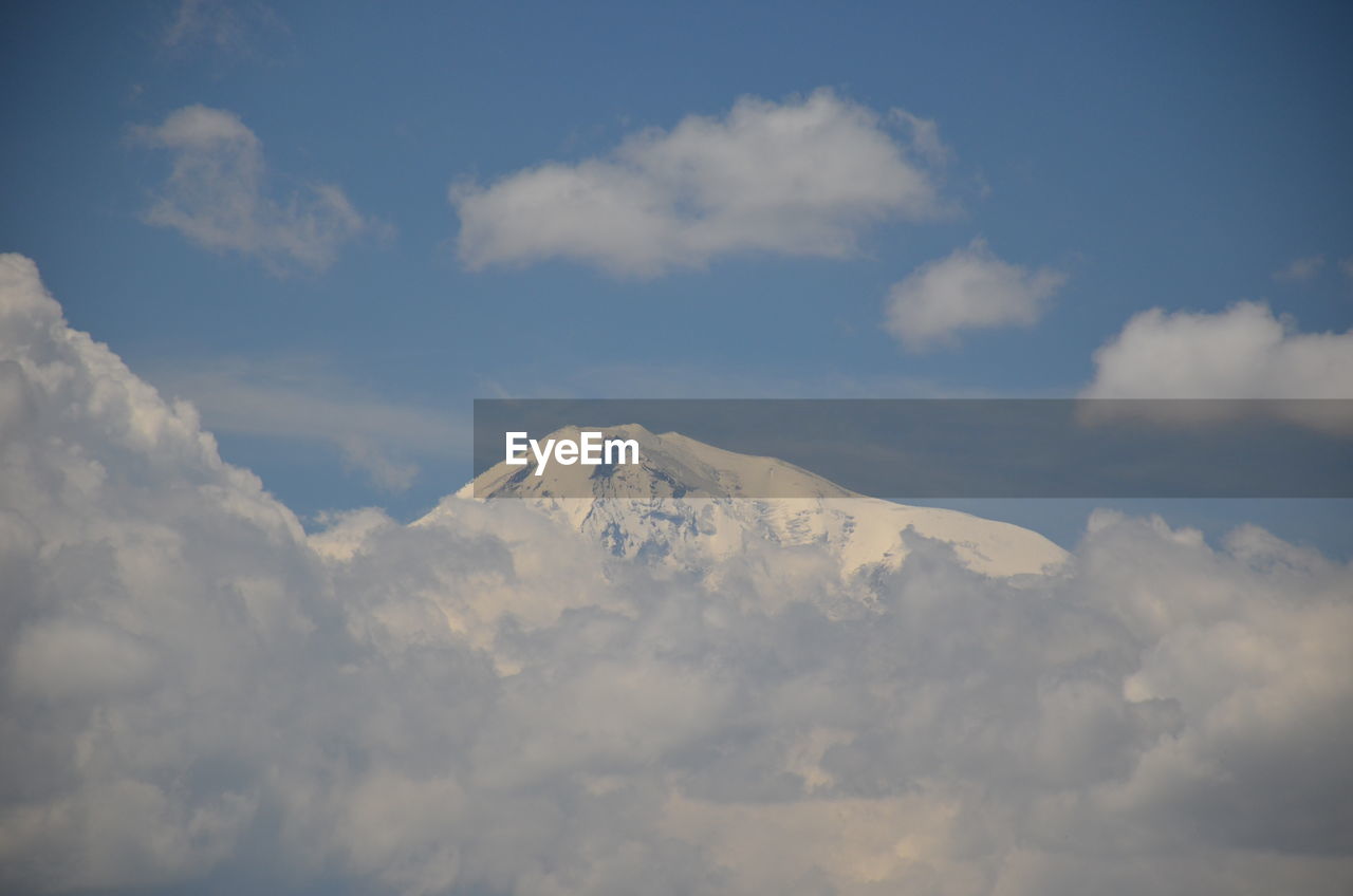 Low angle view of clouds over mountain against sky