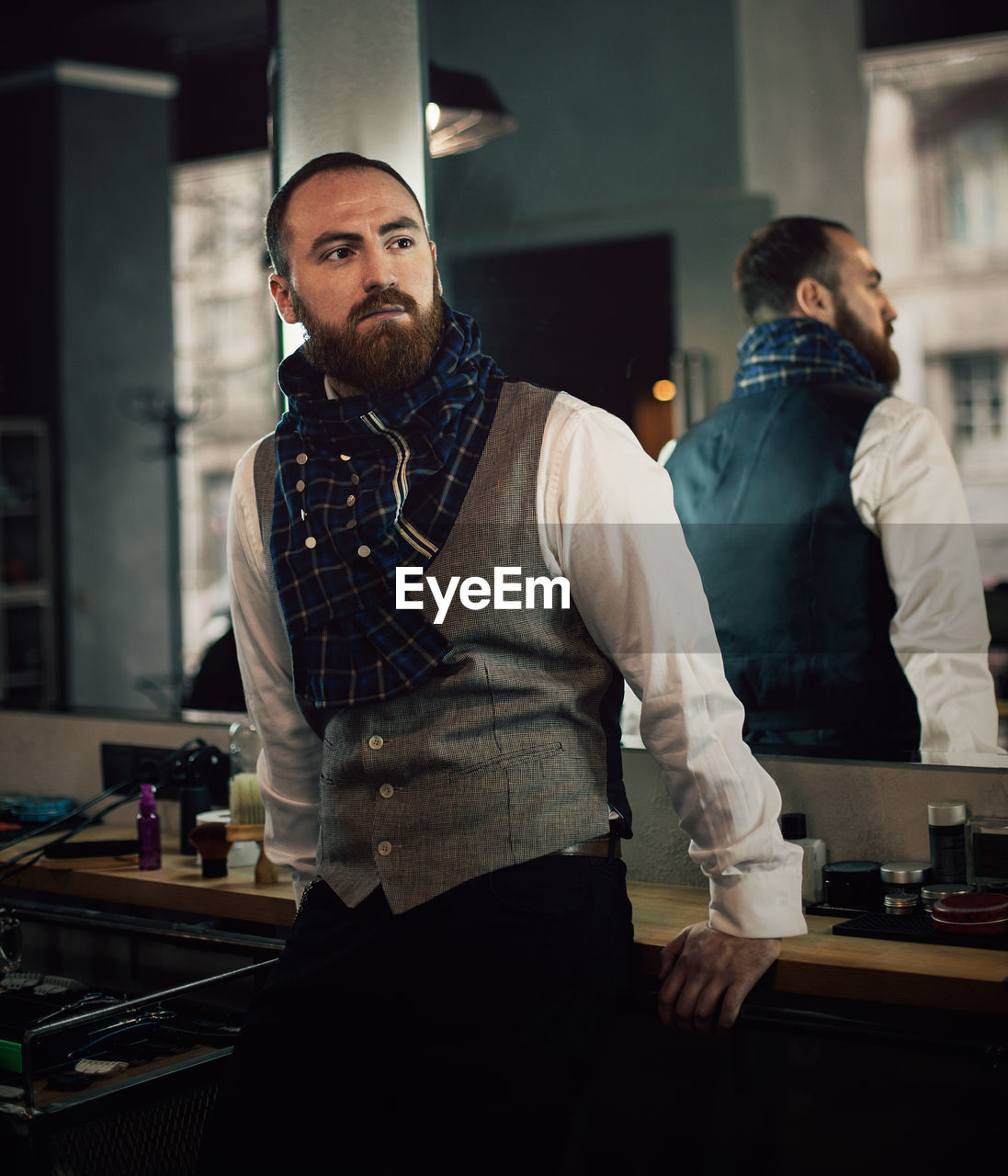 Mid adult bearded man standing in hair salon