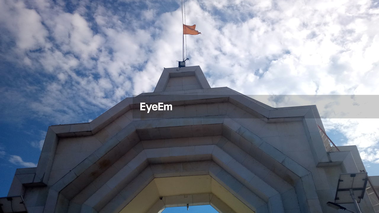 LOW ANGLE VIEW OF FLAG ON BUILDING AGAINST CLOUDY SKY