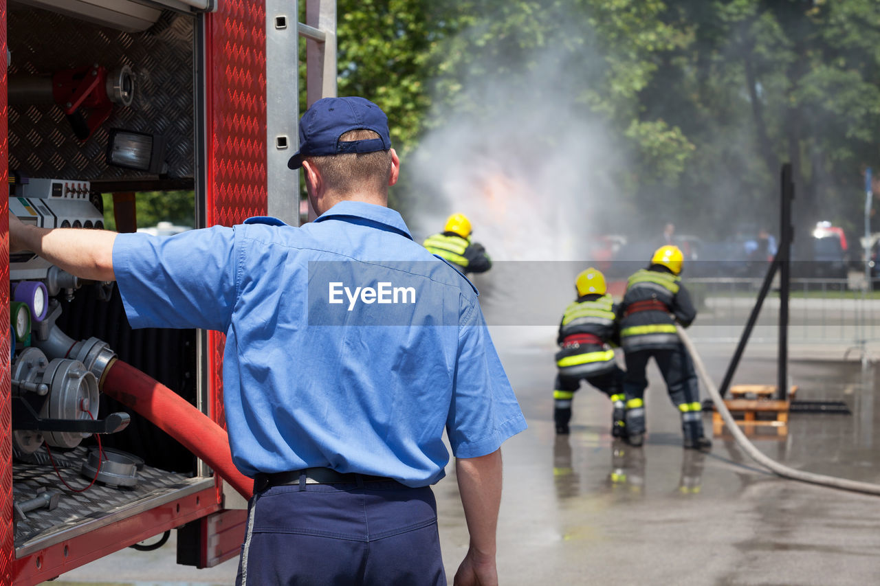 REAR VIEW OF PEOPLE WORKING AT CITY