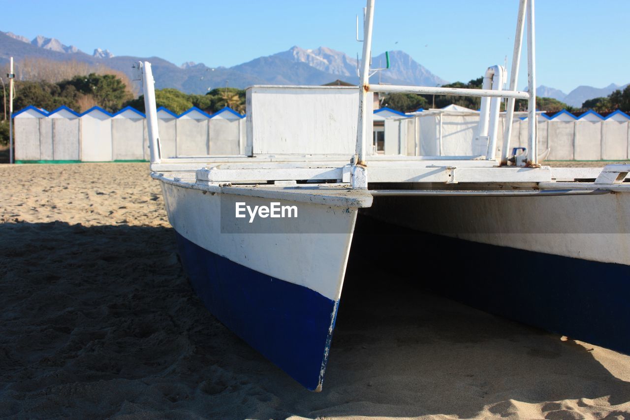 Boat moored on beach against sky