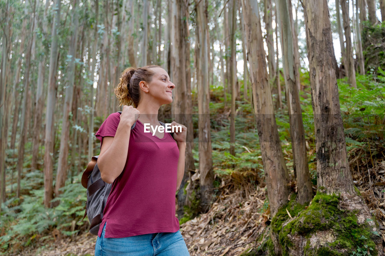 WOMAN STANDING IN FOREST