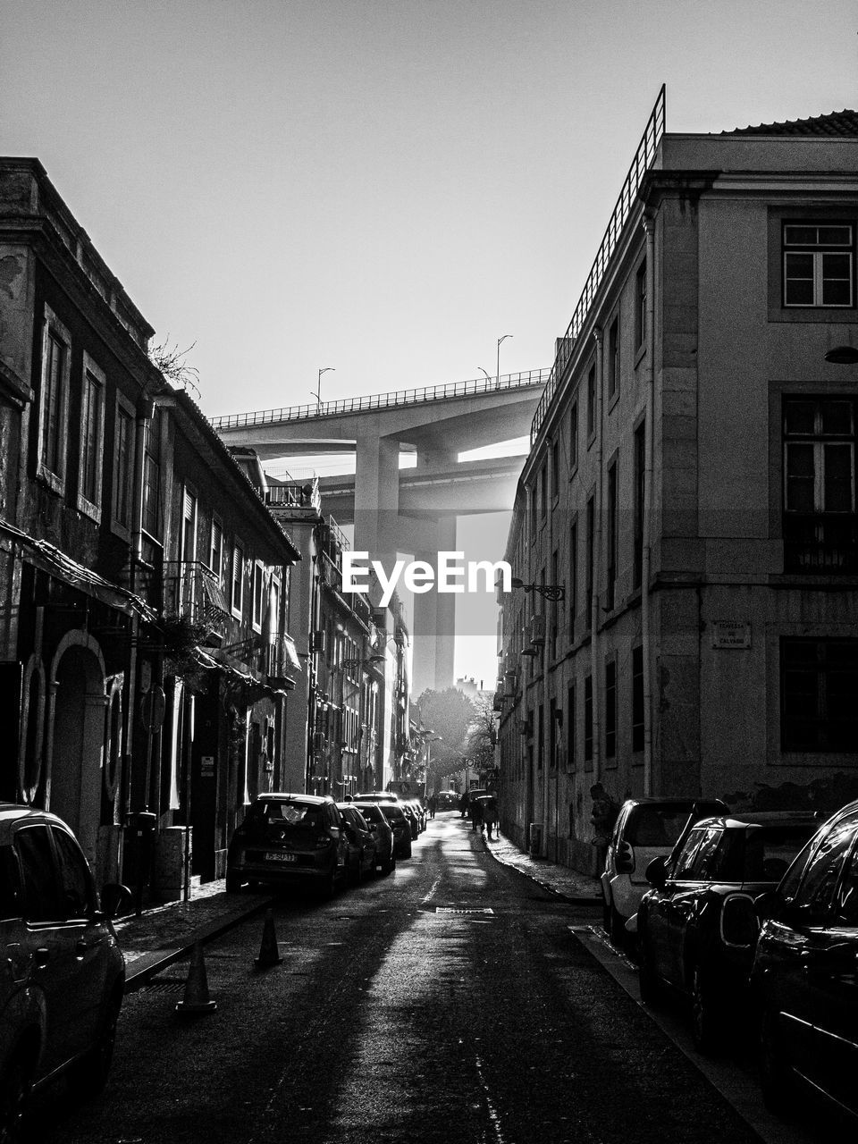 CARS ON ROAD AMIDST BUILDINGS AGAINST SKY