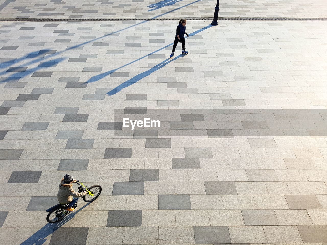 HIGH ANGLE VIEW OF MEN ON COBBLESTONE