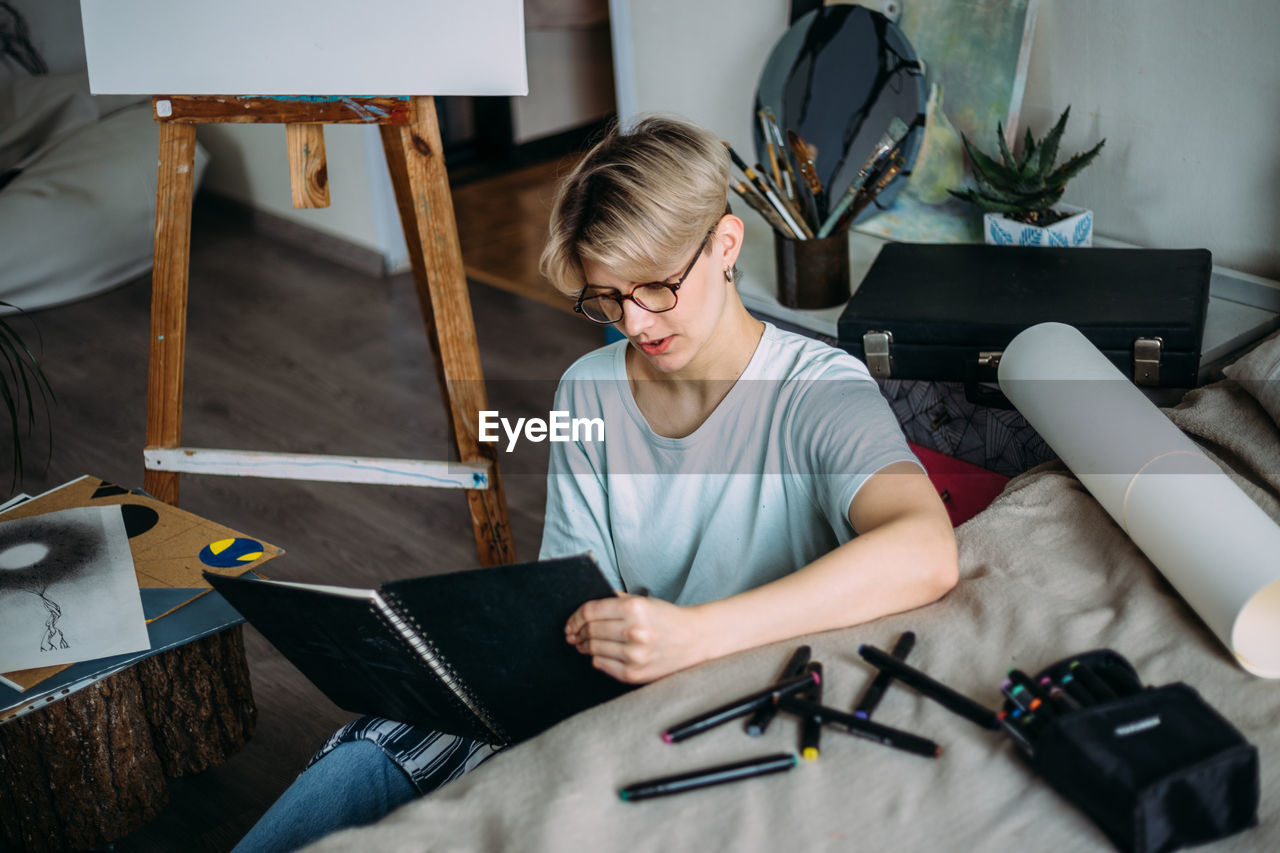 High angle view of woman reading while sitting at home