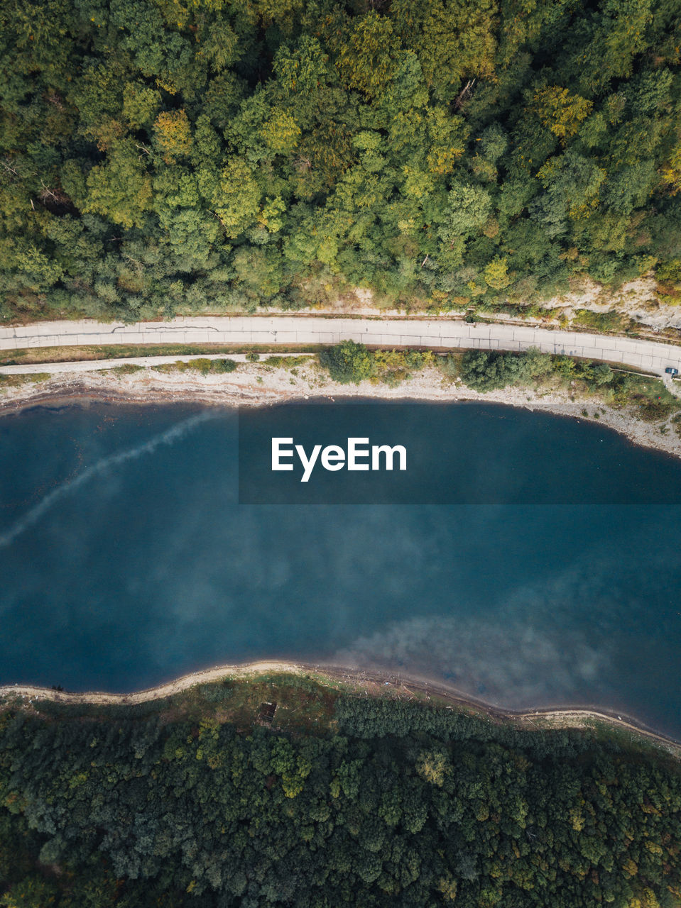 Scenic aerial view of forest lake and green forest near the road. travel concept.