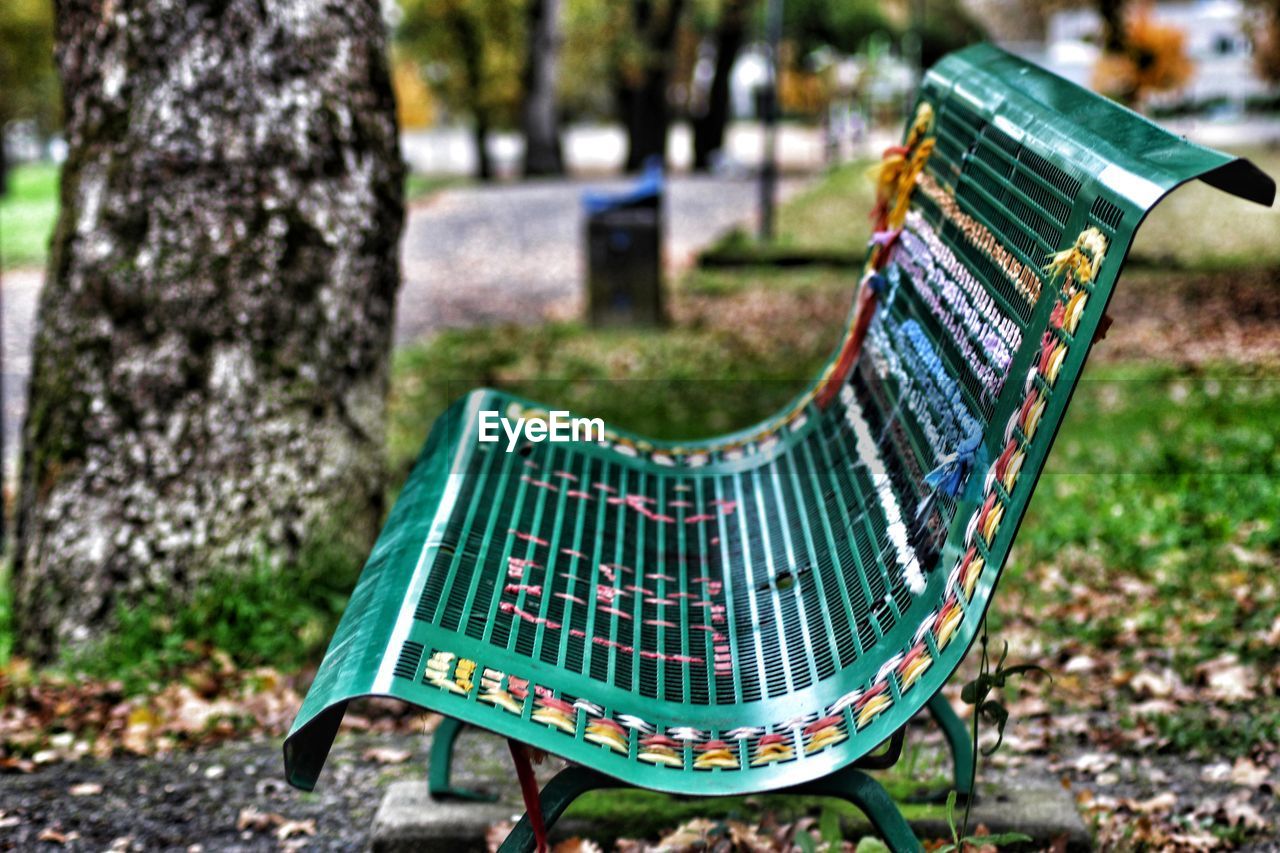 Close-up of empty bench in park