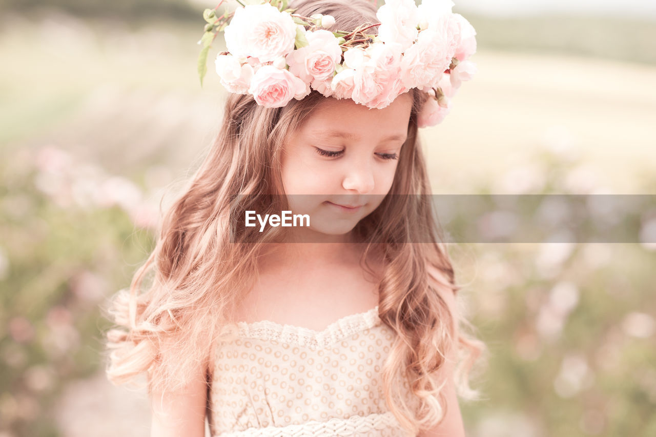 Cute girl wearing wreath standing on field