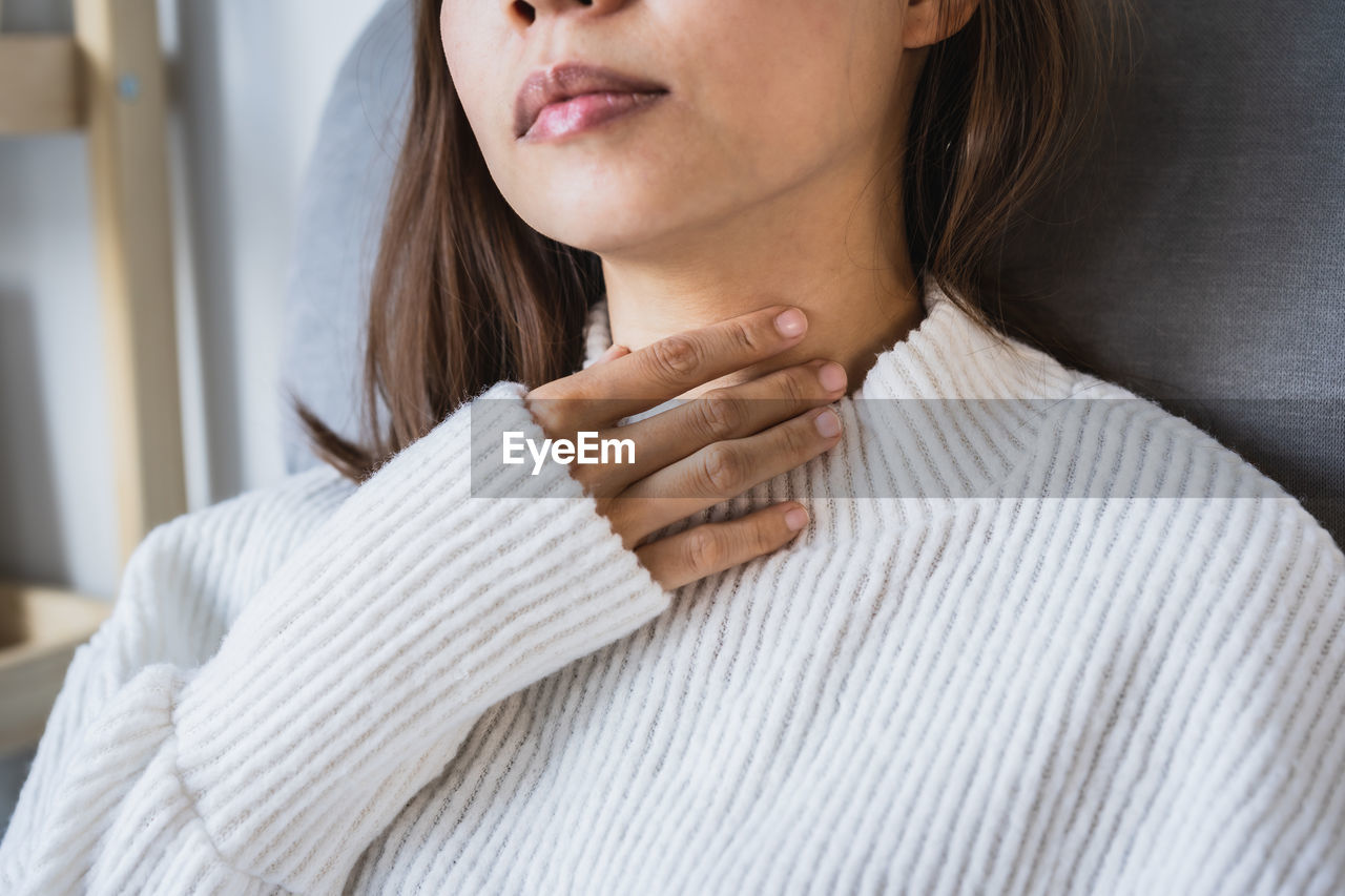 Midsection of woman wearing white sweater