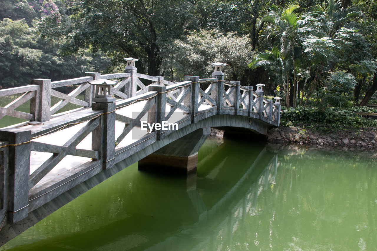 Bridge over river against trees